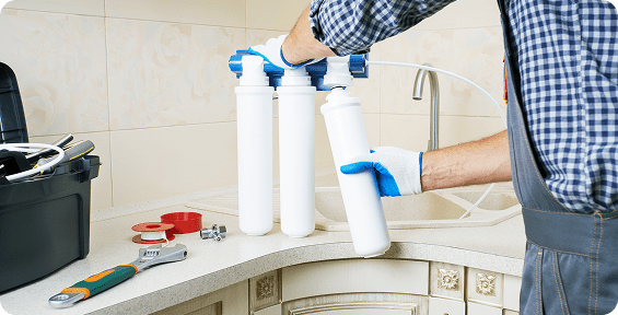 Installing water filtration system under sink.